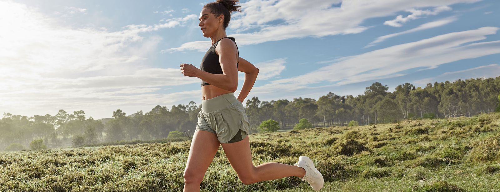 A female runner runs outside on a sunny day in the Nimbus Mirai™