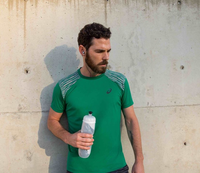 man in green shirt holding a water bottle