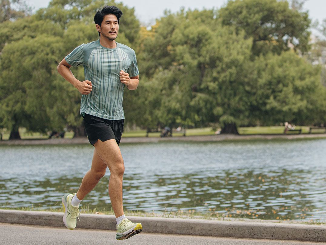 A male model runs by a lake wearing the Gel-Kayano™ 31 shoes