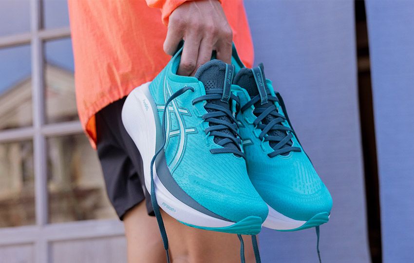 GEL-NIMBUS 27 shoe held by runner