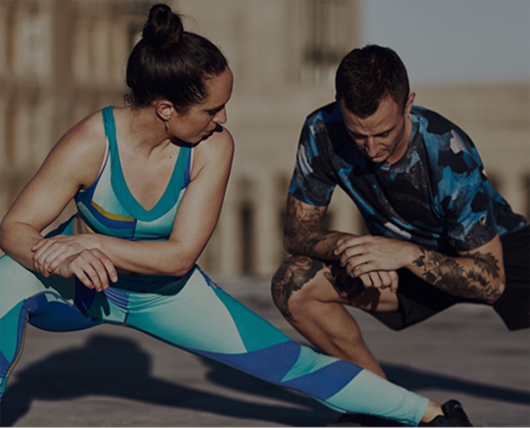 Man and woman in athletic clothing doing lunges.
