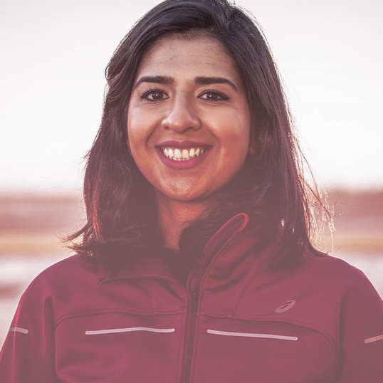 Close up of a woman smiling in an ASICS jacket 
