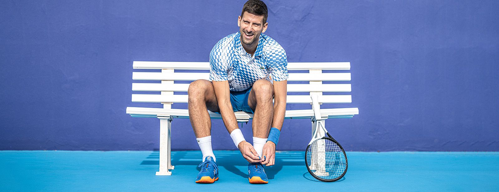 Novak lacing up his Court FF™ sneakers.