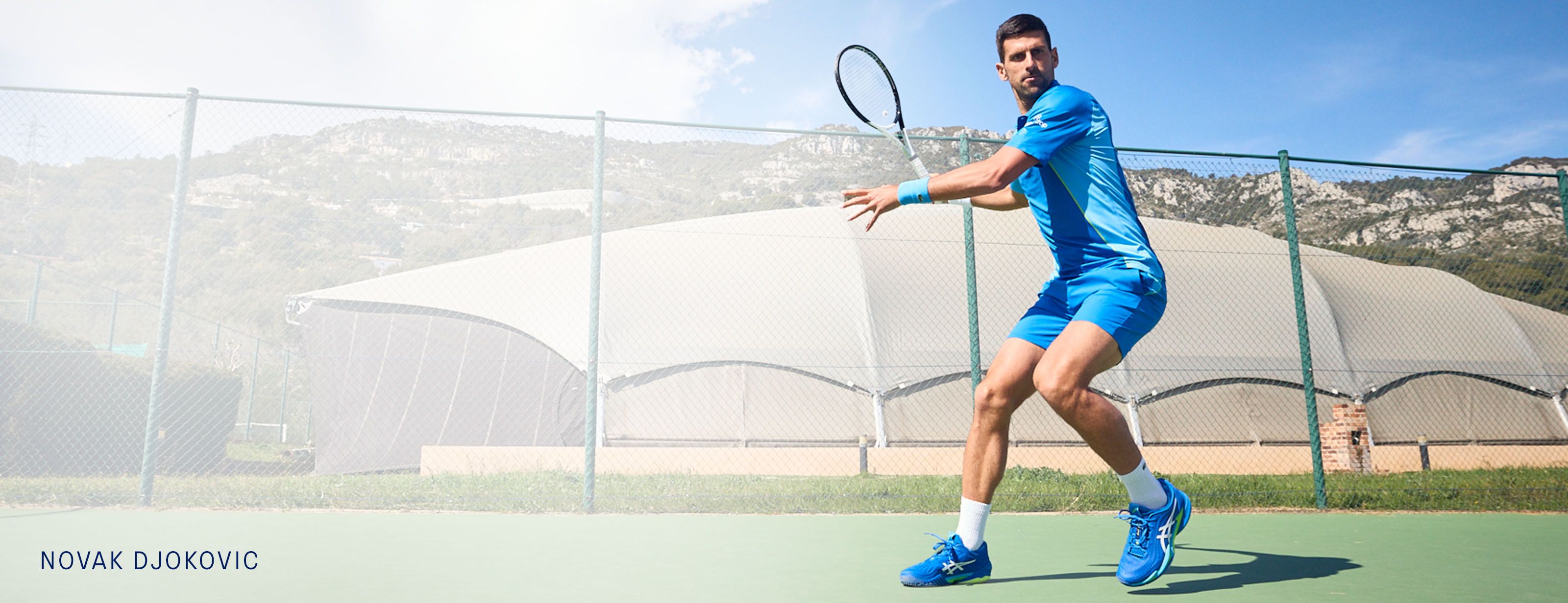 Novak Djokovic plays tennis on the hard court.